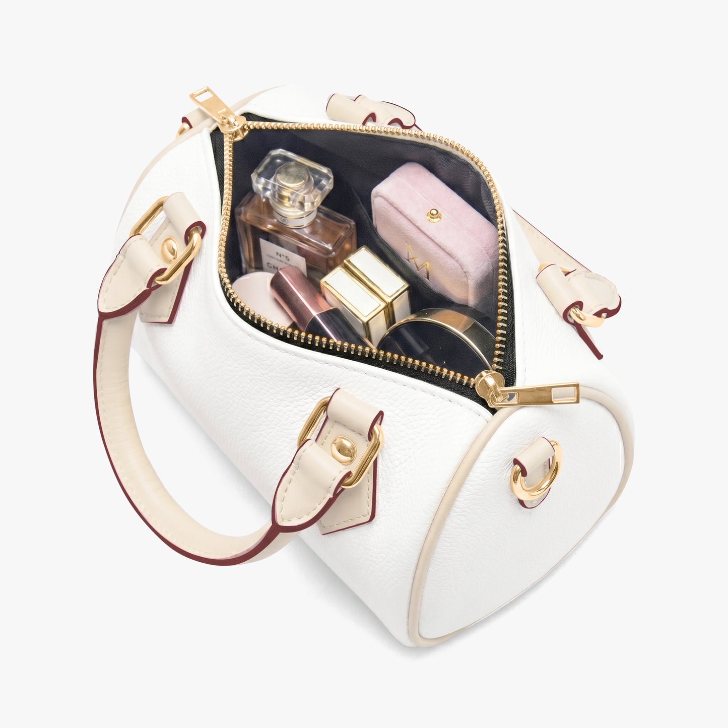 A white leather handbag with a gold zipper and handles, containing various makeup items such as a perfume bottle, compact, and other cosmetics.