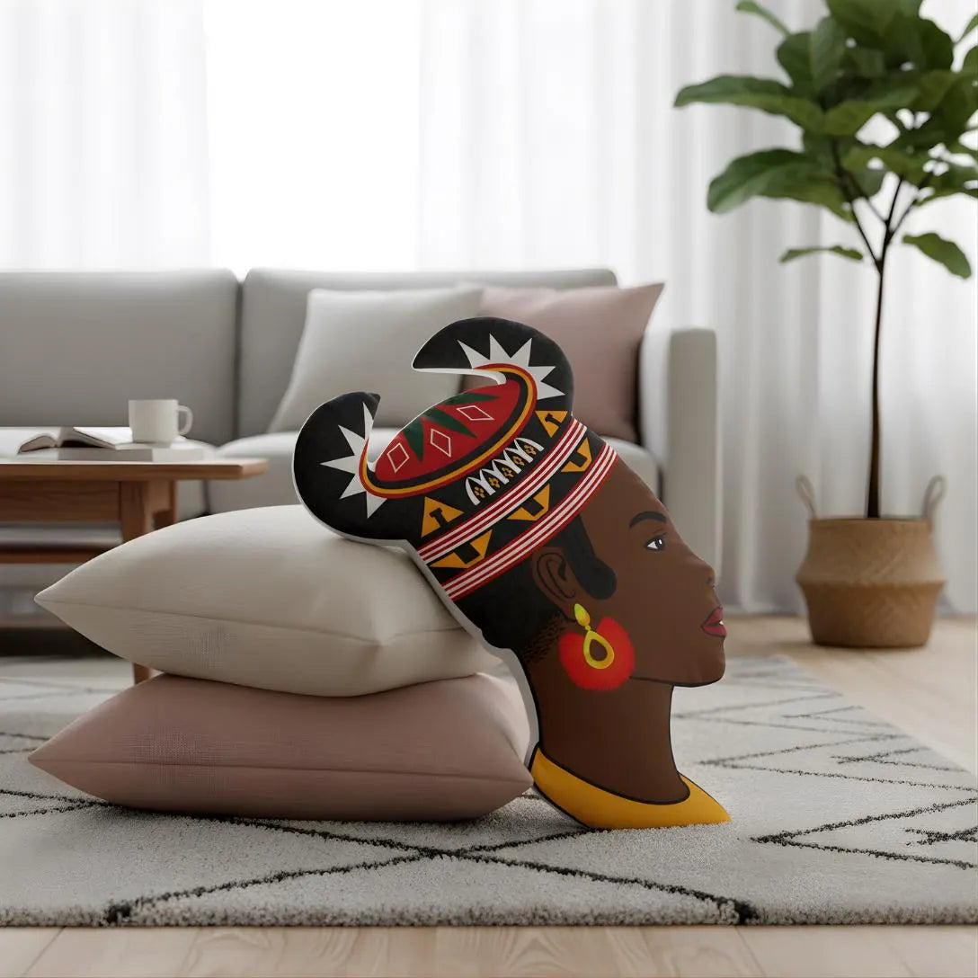 A decorative pillow with a stylized African woman's head design is placed on a rug in a living room setting.