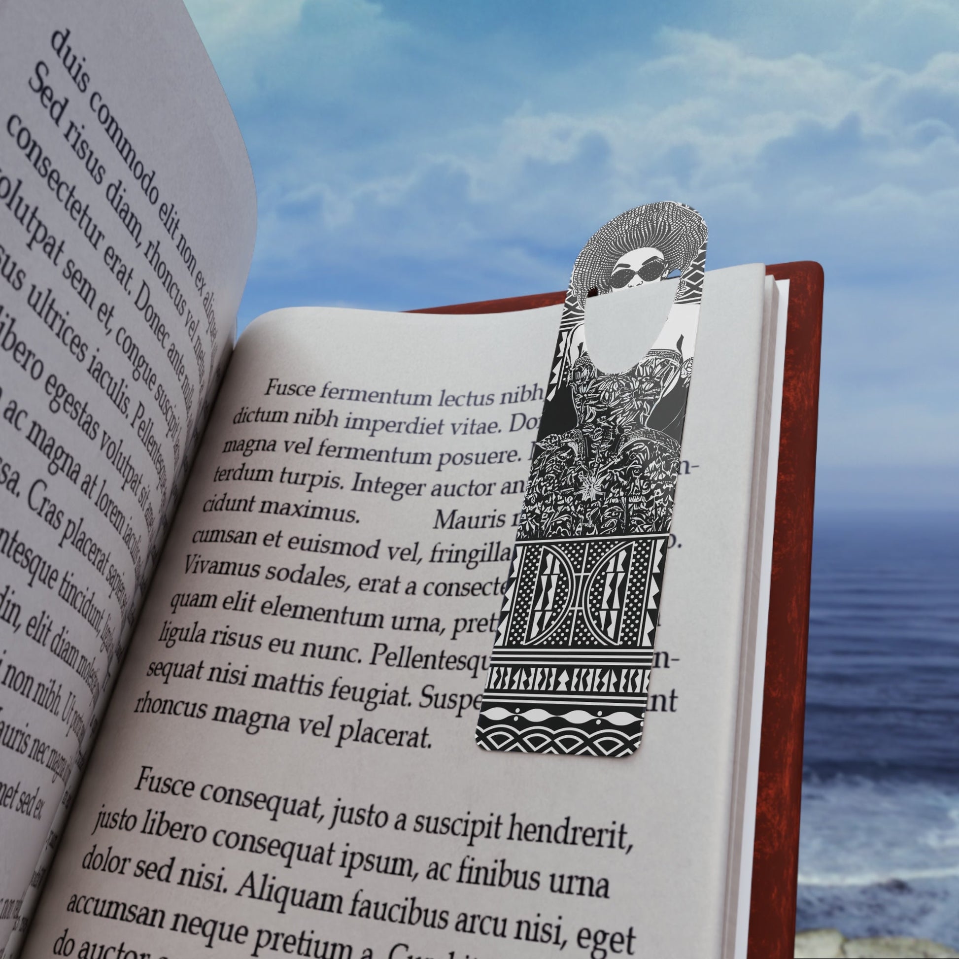 May include: Black and white metal bookmark features an intricate design. The bookmark is shaped like a tall rectangle with a decorative top. The design includes geometric patterns and stylized figures.  The bookmark is shown inserted into the pages of an open book. Text on the book page includes Latin text.  The bookmark is a stylish and functional accessory for book lovers.