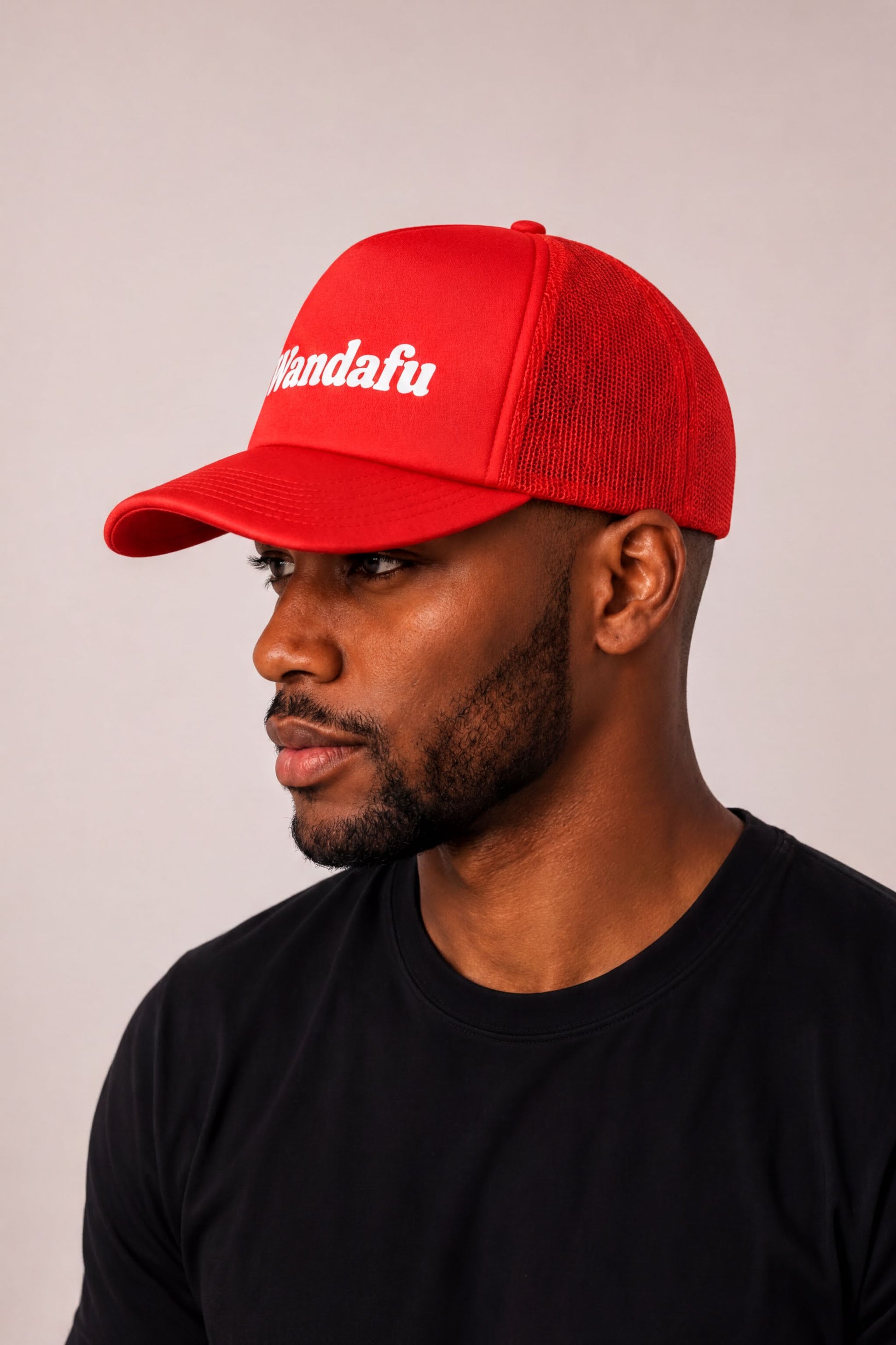 A man wearing a red baseball cap with the word "Vandafu" printed on it.