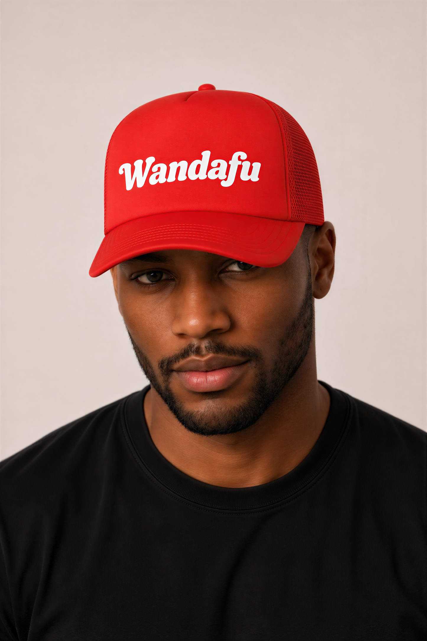 A man wearing a red baseball cap with the word "Wandafu" printed on it.