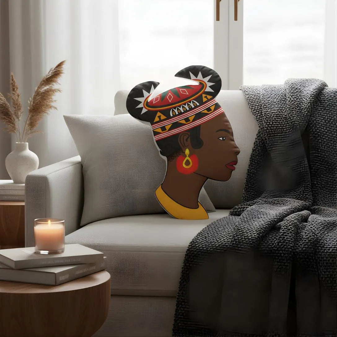 a cozy living room setting with a gray sofa, a candle on a small table, and a decorative pillow depicting a woman's profile.