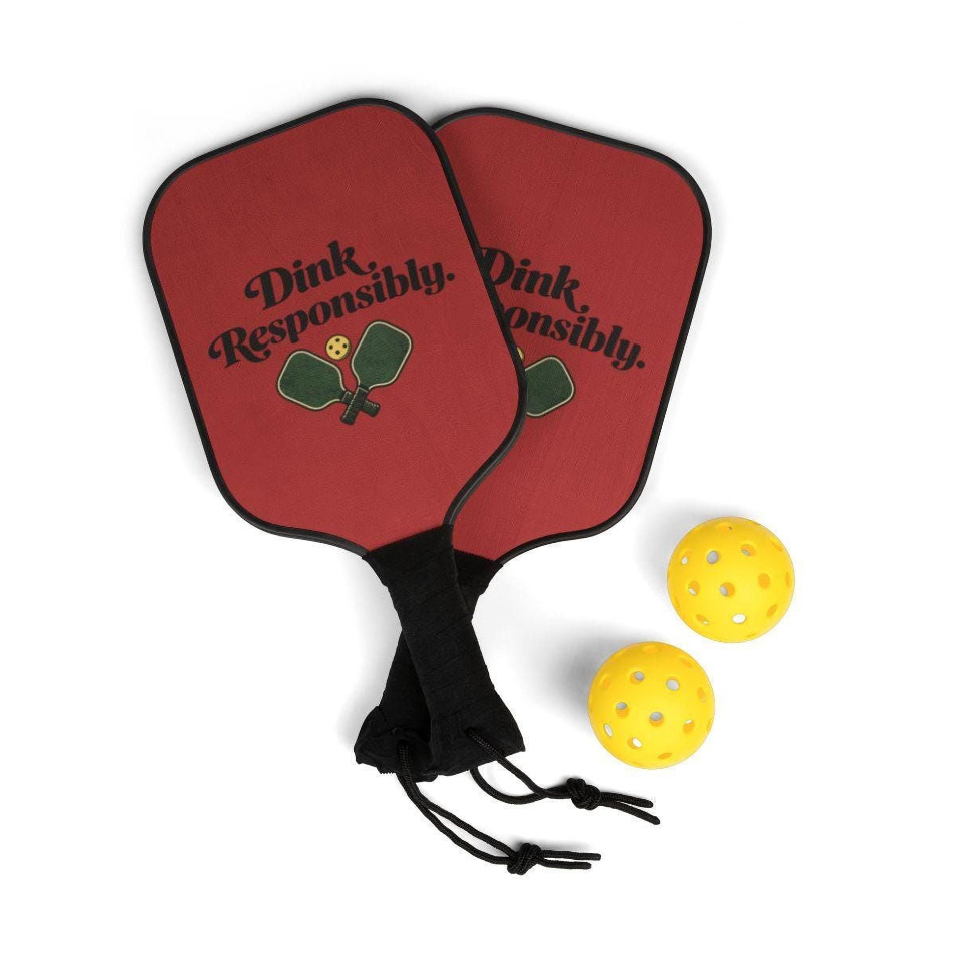 a pair of red paddleball rackets with the text "Dink Responsibly" printed on them, along with two yellow paddleball balls.