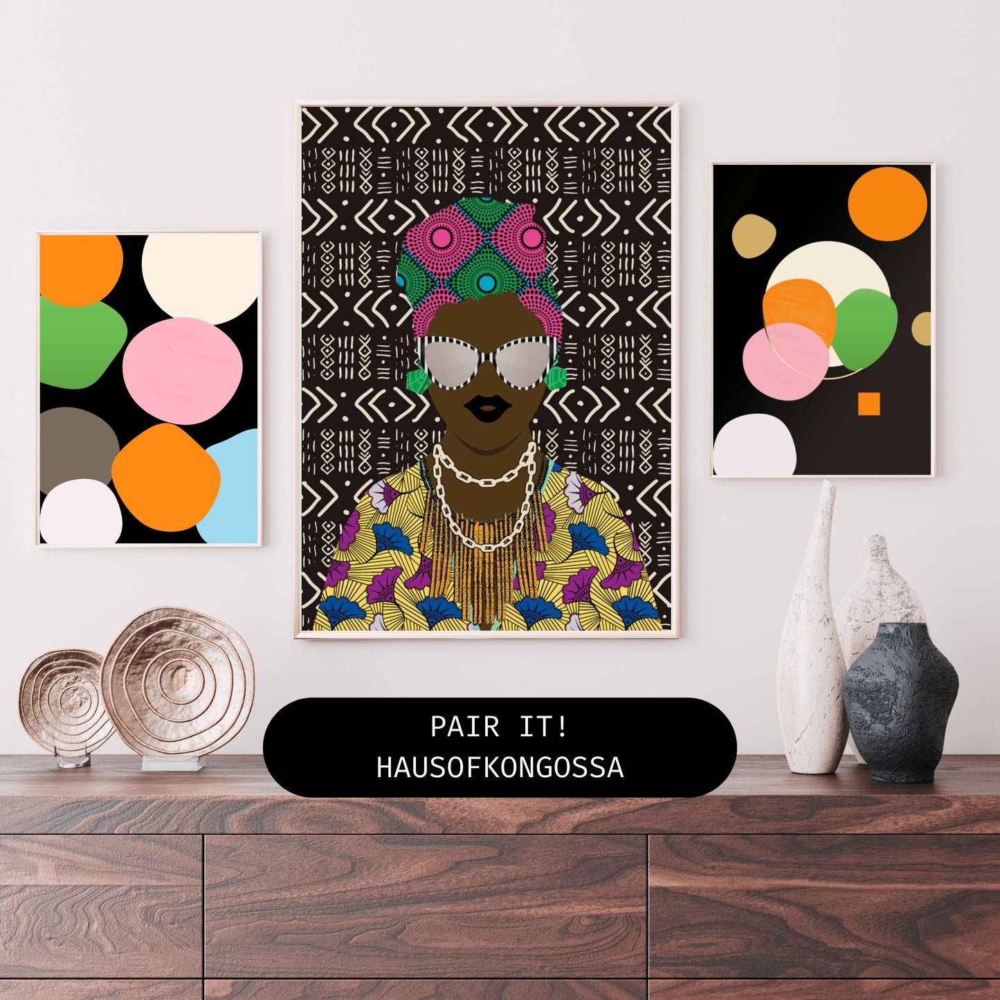 a wooden dresser with a framed artwork of a woman wearing a colorful headdress and a patterned dress, along with two other framed artworks on the wall.