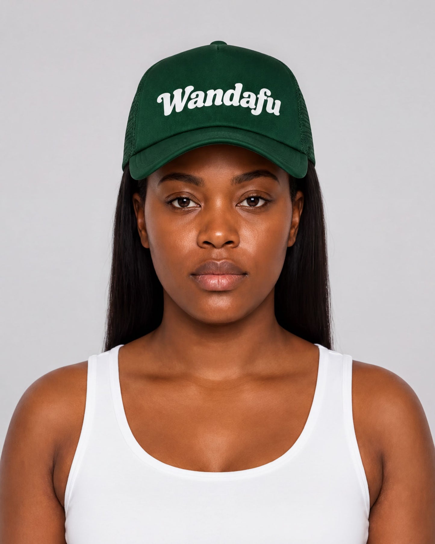 A woman wearing a green baseball cap with the word "Wandafu" printed on it.