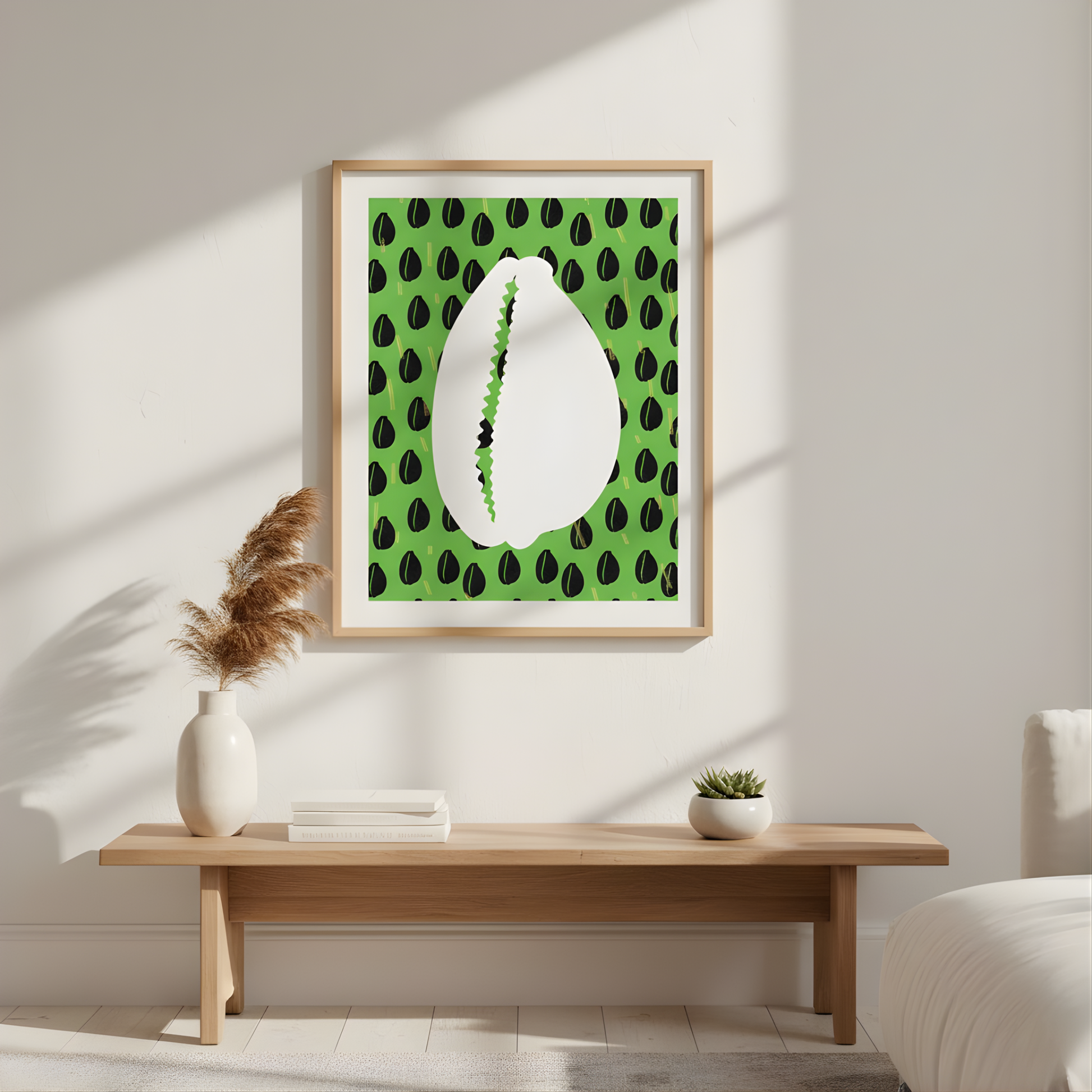 a wooden table with a white vase and a stack of books on it, set against a white wall with a framed picture of a shell with green leaves hanging above it.