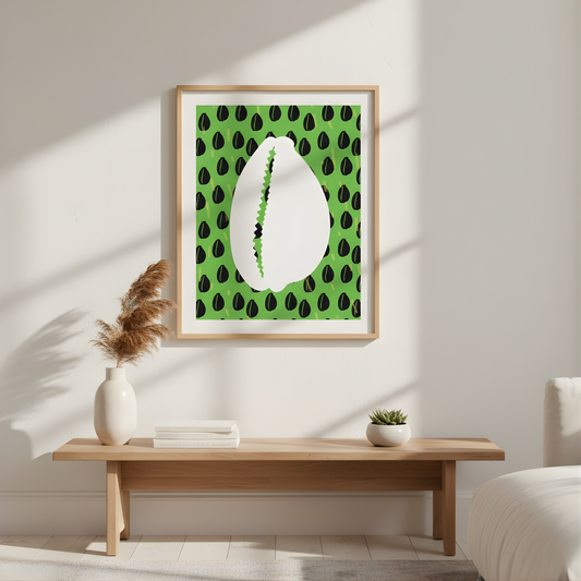 a wooden table with a white vase and a stack of books on it, set against a white wall with a framed picture of a shell with green leaves hanging above it.