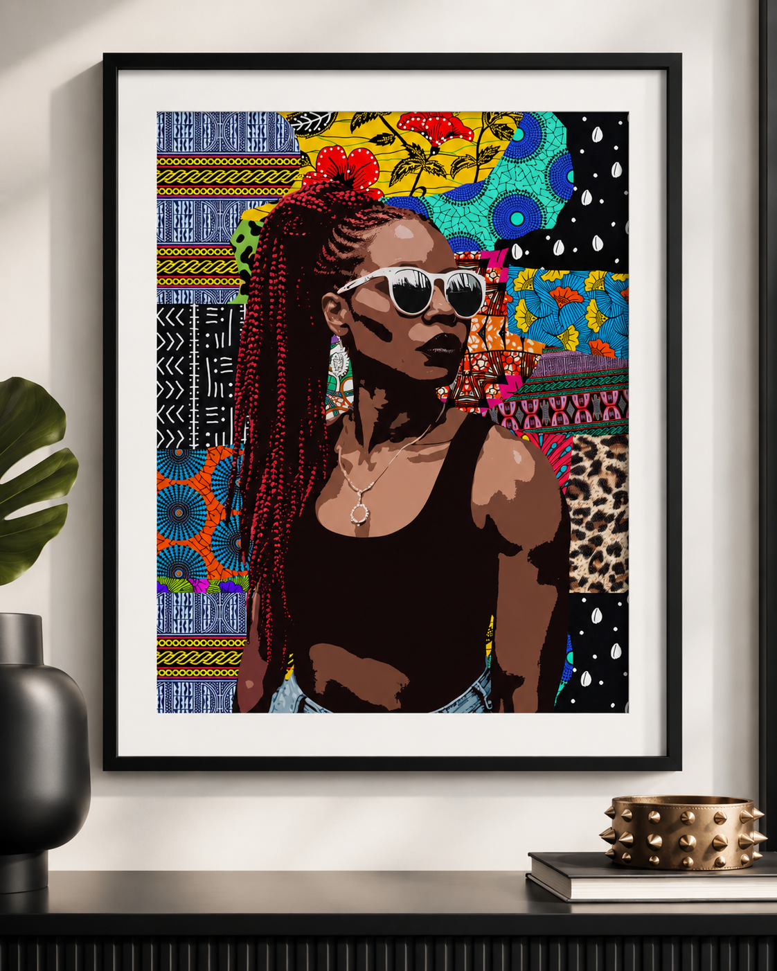 A framed print of a woman with braided hair and sunglasses, wearing a black tank top, is displayed on a wall.