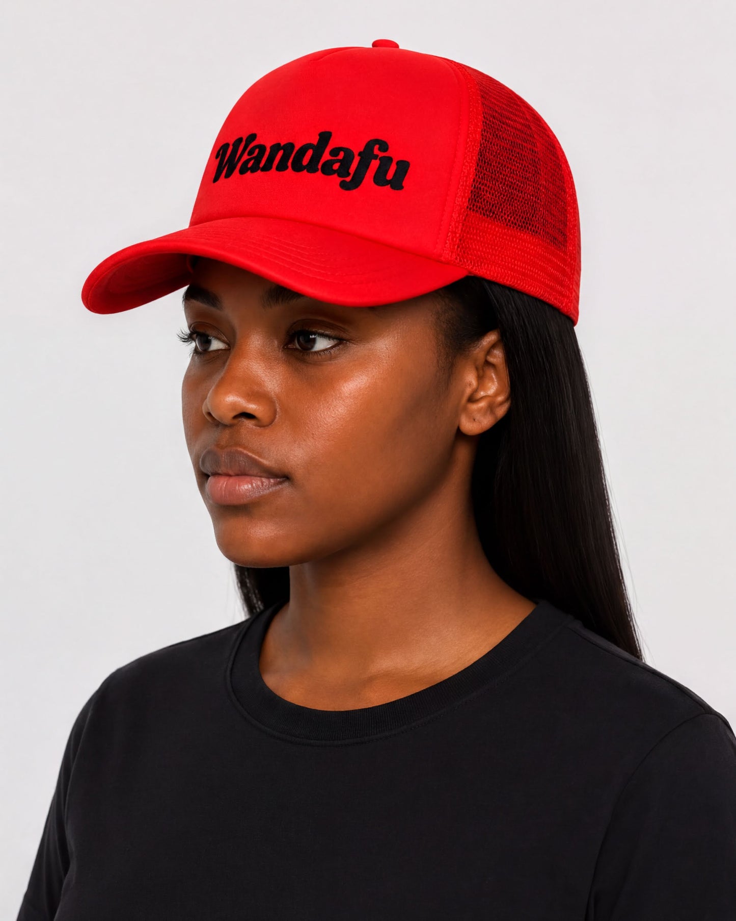 A woman wearing a red baseball cap with the text "Wandafu" printed on it.