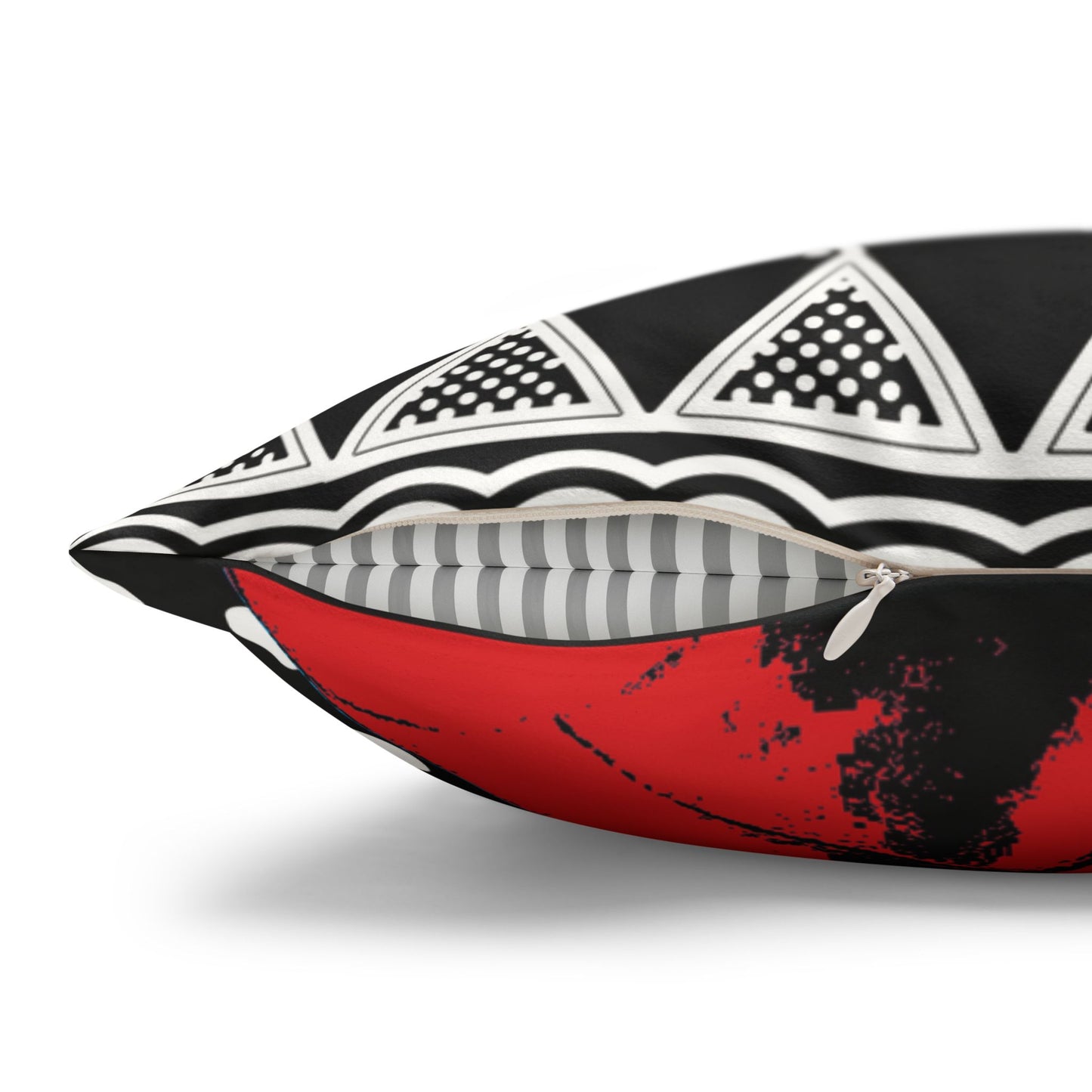 a close-up view of a black and white pillow with a striking red and black pattern.