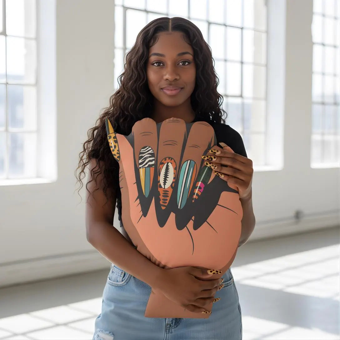 A young woman with long curly hair is holding a large cardboard cutout of a hand with painted nails.