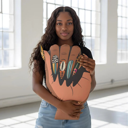 A young woman with long curly hair is holding a large cardboard cutout of a hand with painted nails.