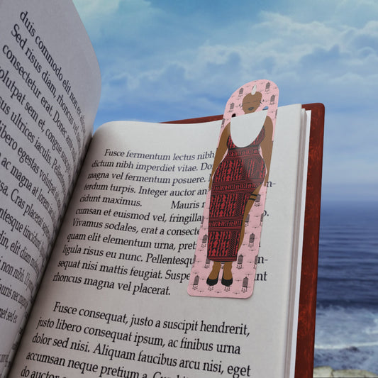 May include: Bookmark featuring a pink background and a dark-red patterned dress. The illustration shows a woman in a knee-length dress with a sleeveless design. The bookmark is placed on an open book with text visible.  The text on the bookmark is not legible. The book's text is in a serif font.
