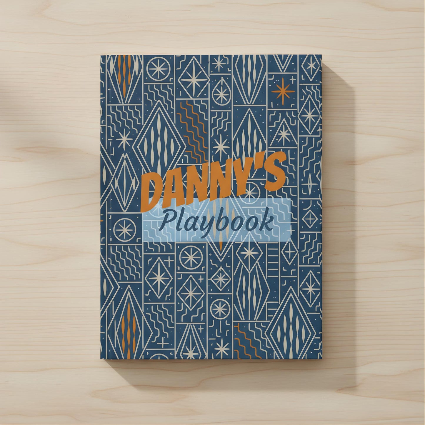 The image is a book cover with a geometric pattern in shades of blue and orange. The title "DANY'S Playbook" is prominently displayed in the center of the cover.