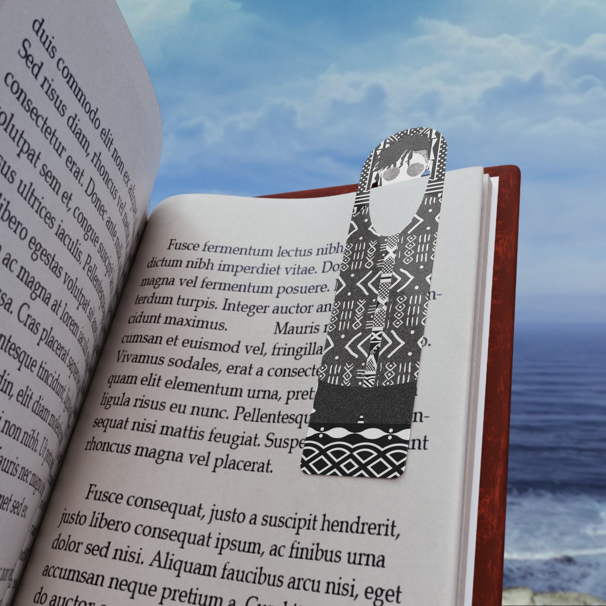 May include: Black and white patterned bookmark featuring a stylized person. The bookmark is made of paper and has a geometric design.  The bookmark is placed in an open book with text visible. The book's pages are cream-colored, and the text is in a serif font. The book is open to a page with Latin text.