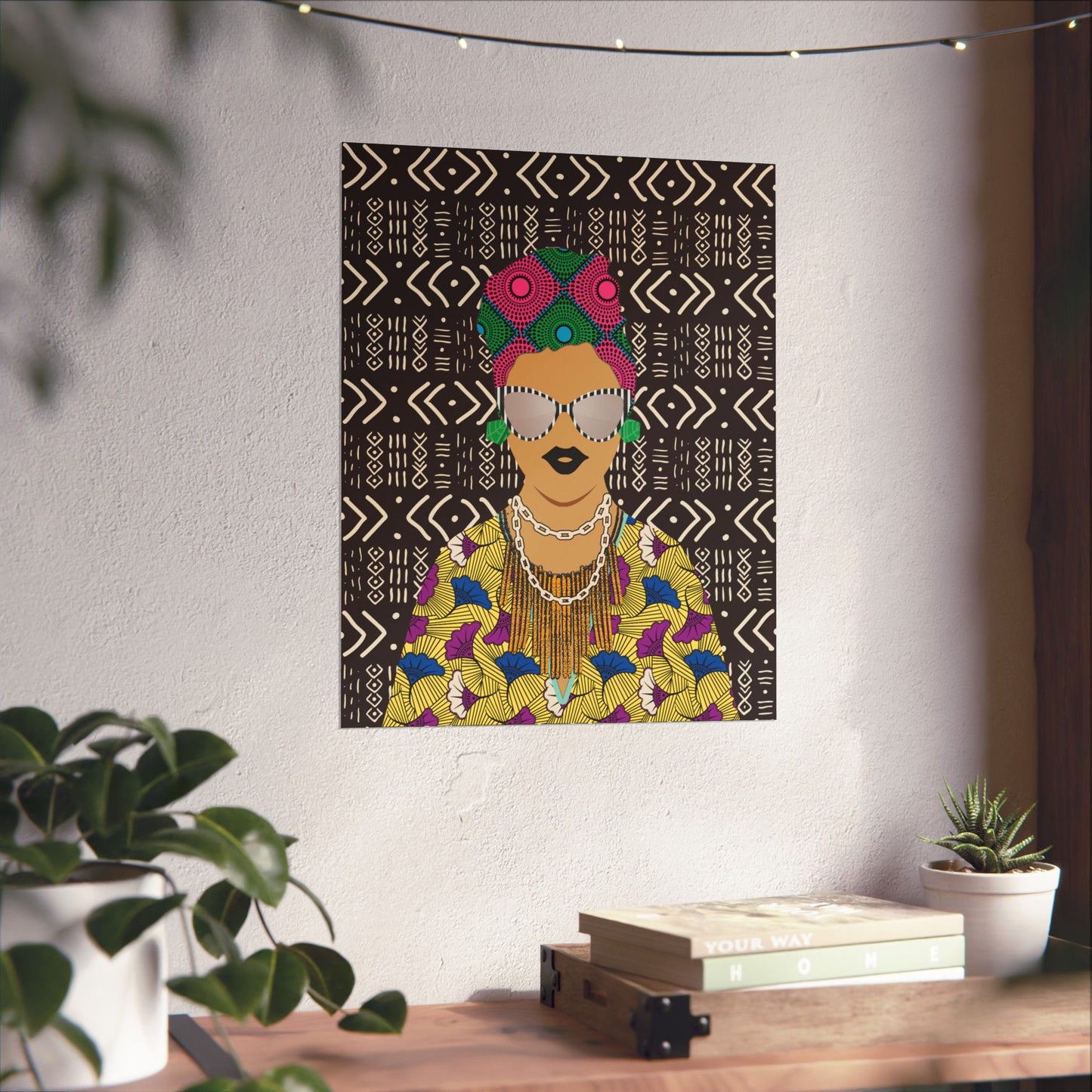 a colorful and vibrant poster of a woman with a headdress, displayed on a wall above a wooden table with various decorative items.