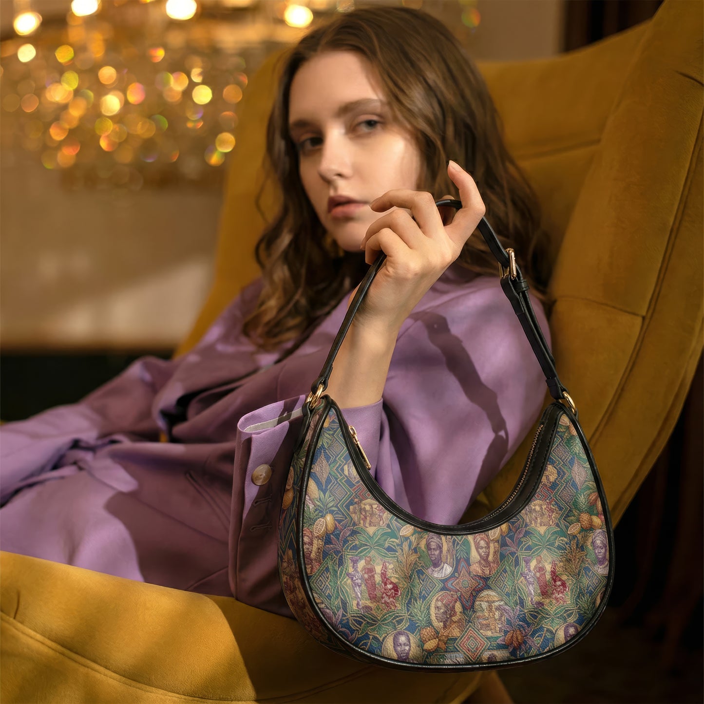 A woman in a purple outfit sits in a yellow armchair, holding a colorful purse with a floral pattern.